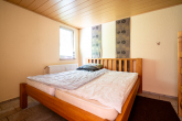 Schlafzimmer Gästewohnung - Einfamilienhaus mit 3 Garagen und zwei Gästewohnungen in naturnaher Lage